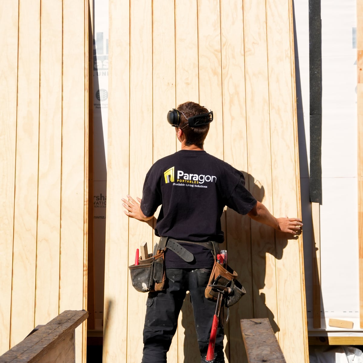 Cladding sheets stood against the framing, ready to be fixed