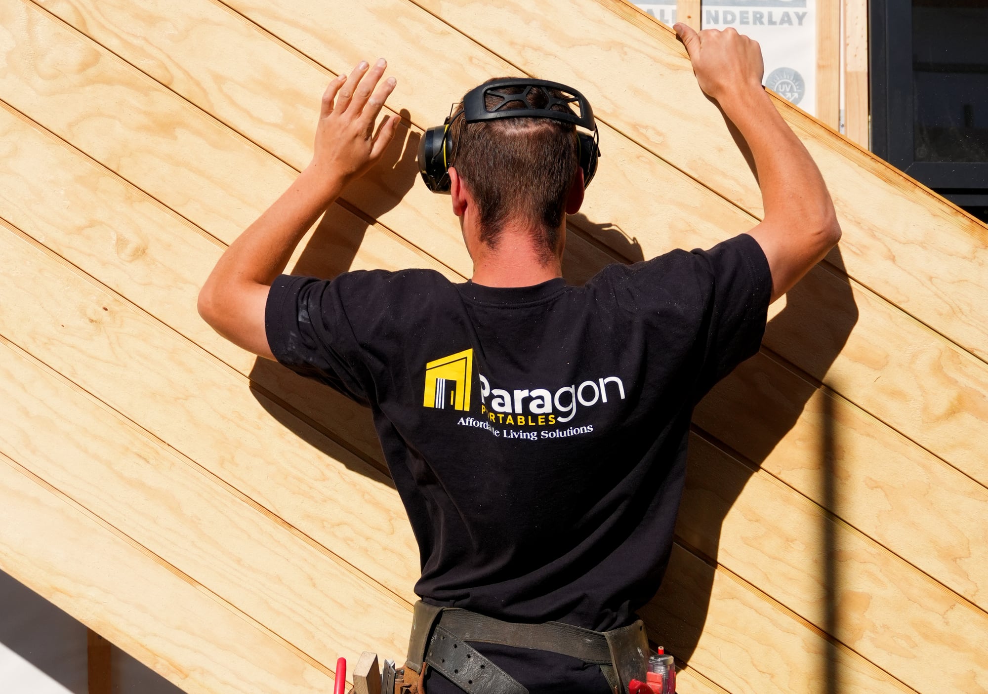 A Paragon Portables builder fitting Shadowclad cladding over the building wrap and cavity battens