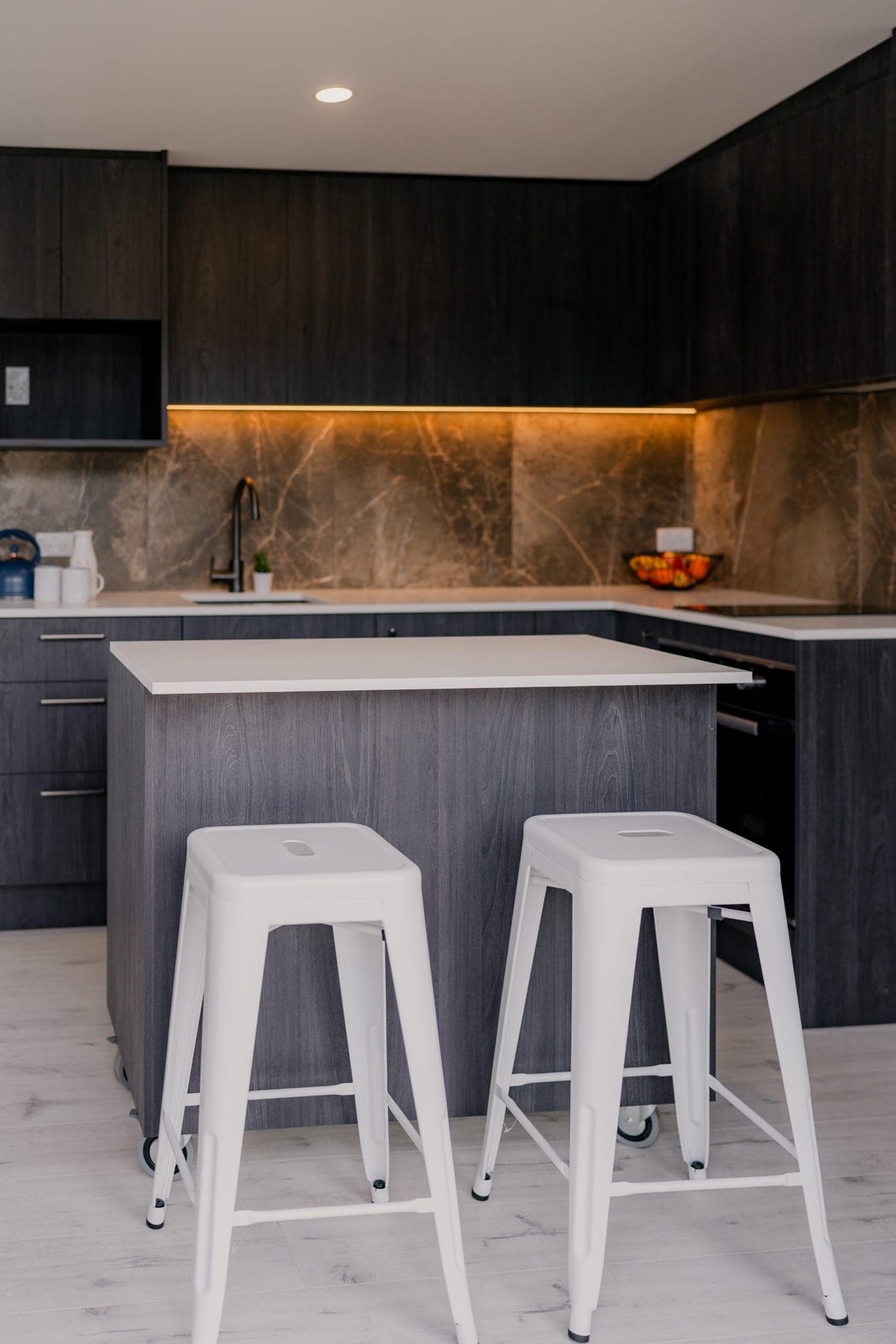 Kitchen island and bar stools with stone splashback