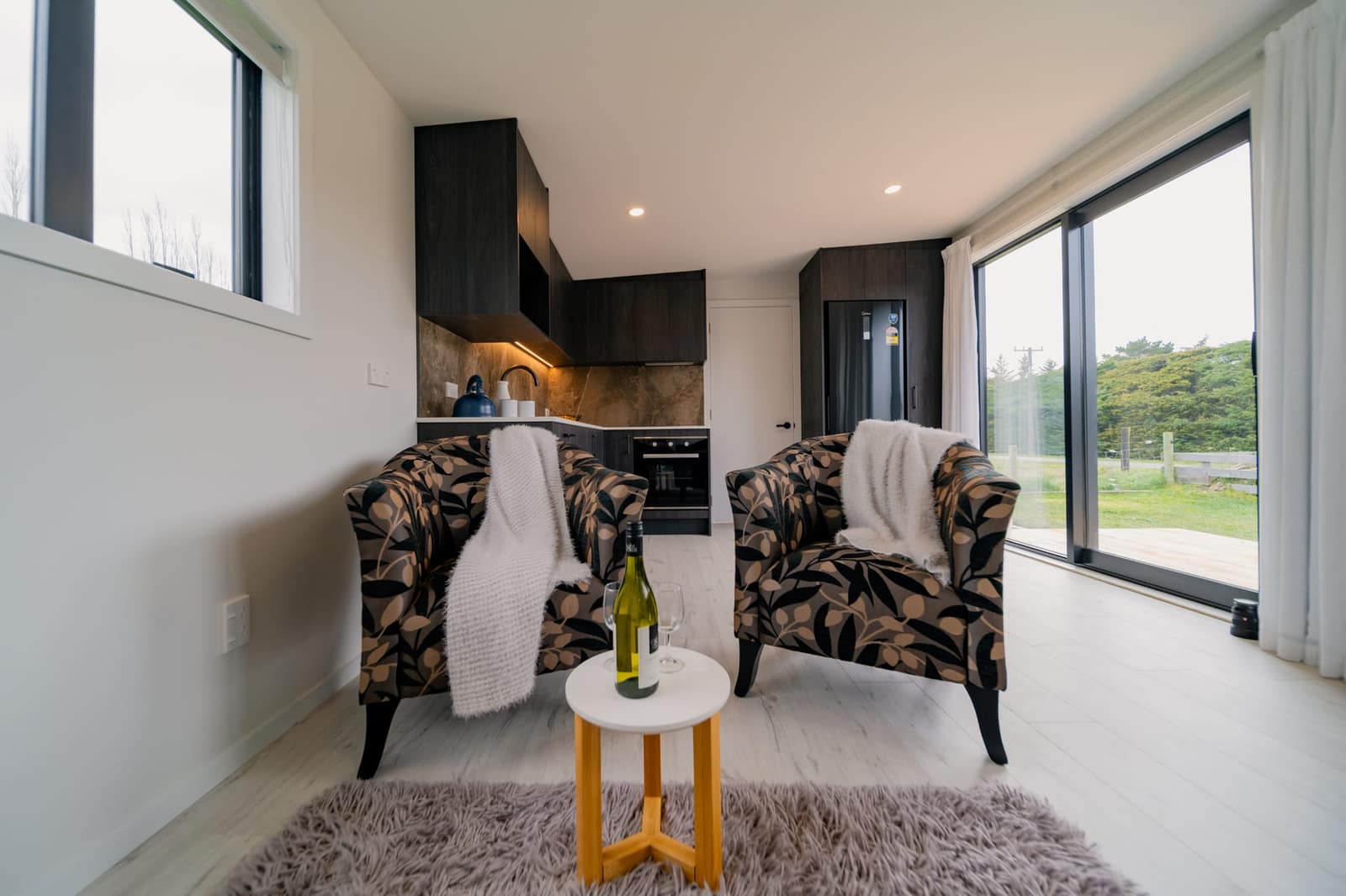 Living area with armchairs beside the kitchen in a Paragon Portables home